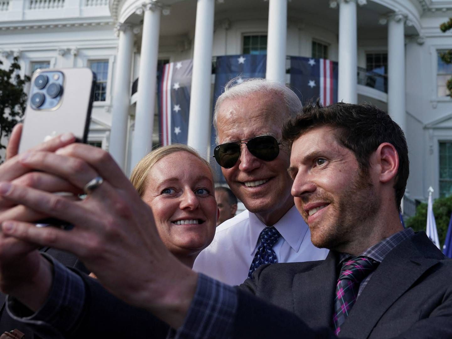 President Joe Biden poses for selfies while celebrating the passing of the Inflation Reduction Act. | Photo: Kevin Lamarque/Reuters/Ritzau Scanpix