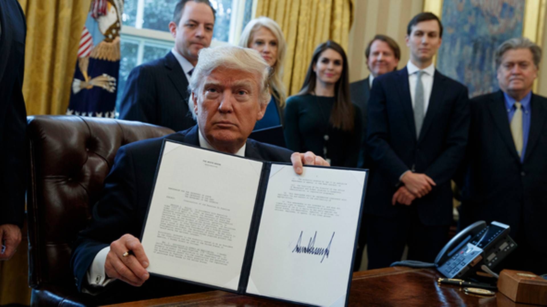 Præsident Trump fremviser det underskrevne dekret, der giver tilladelse til byggeriet af olierørledningerne Keystone XL og Dakota Access. | Foto: Evan Vucci/AP Photo/Polfoto