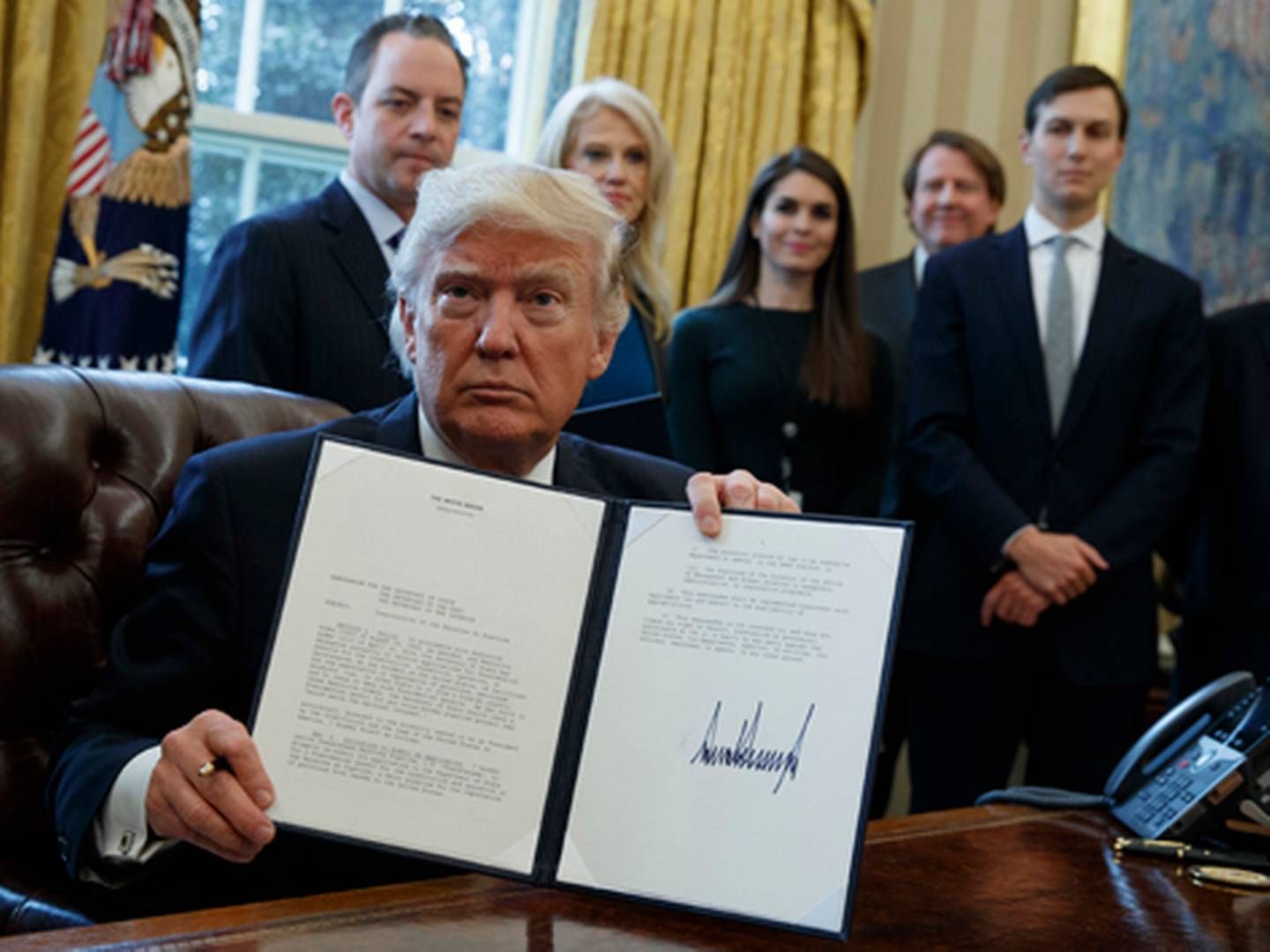 Præsident Trump fremviser det underskrevne dekret, der giver tilladelse til byggeriet af olierørledningerne Keystone XL og Dakota Access. | Foto: Evan Vucci/AP Photo/Polfoto