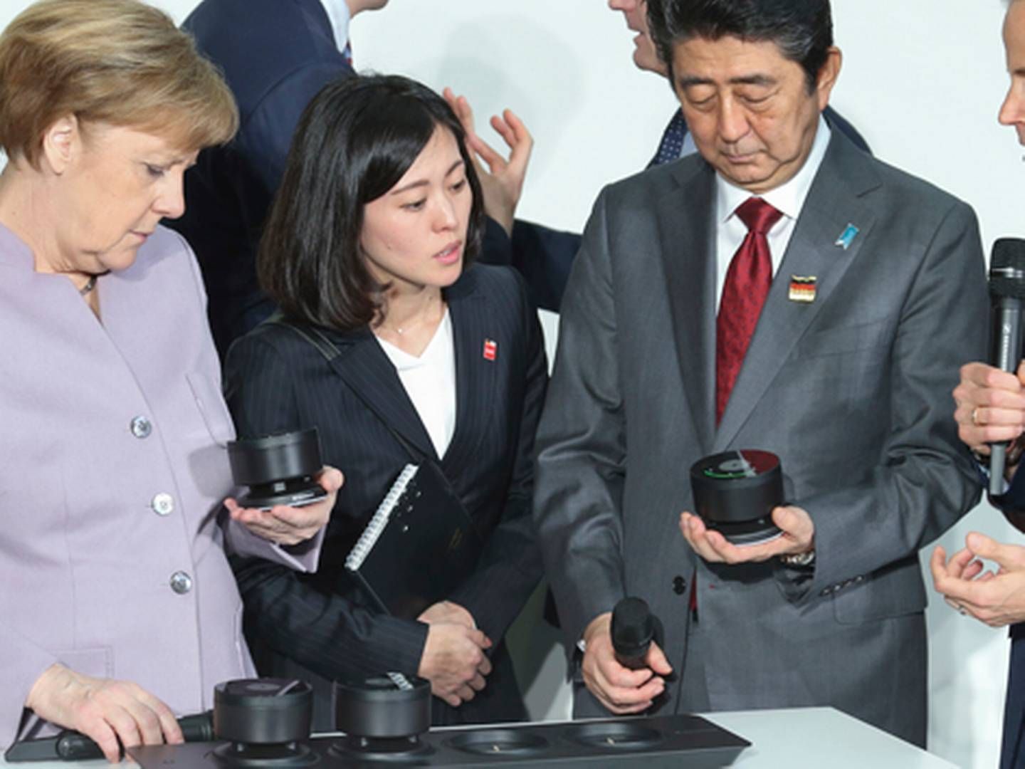 Den tyske kansler Angela Merkel inspicerer Sennheisers produkter på Cebit-messen sammen med den japanske ministerpræsident Shinzo Abe og Andreas Sennheiser ydest til højre.